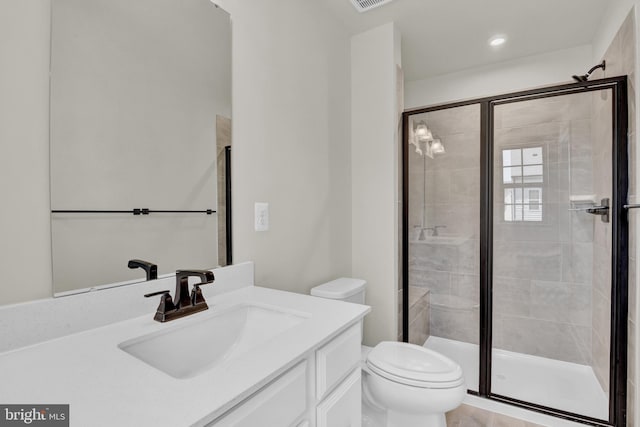 bathroom with walk in shower, vanity, and toilet