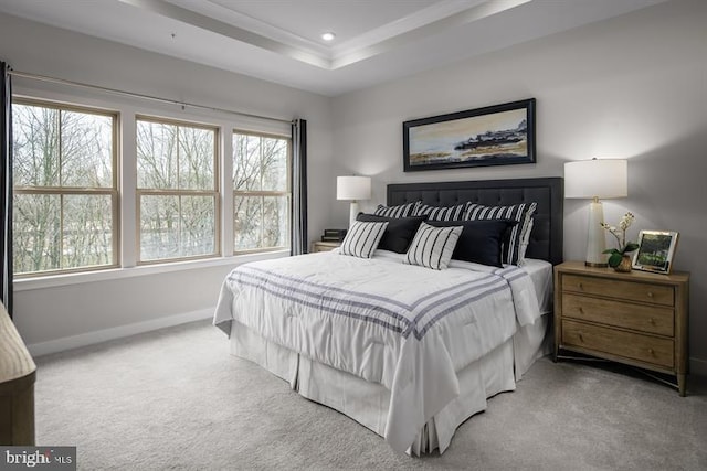 carpeted bedroom featuring a tray ceiling and multiple windows