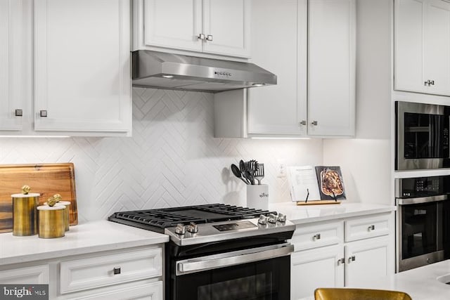 kitchen with appliances with stainless steel finishes, decorative backsplash, white cabinetry, and range hood