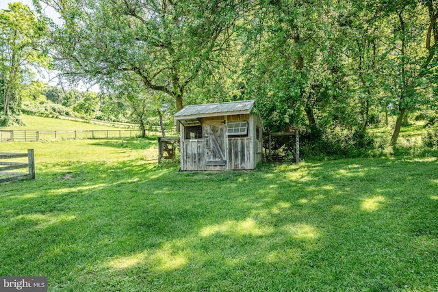 view of outbuilding with a lawn and a rural view