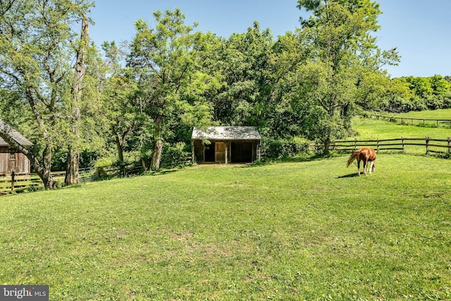 view of yard featuring a rural view and an outdoor structure