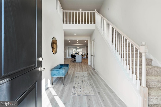 entrance foyer featuring a towering ceiling and light hardwood / wood-style flooring