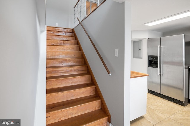 stairs with tile patterned floors and electric panel