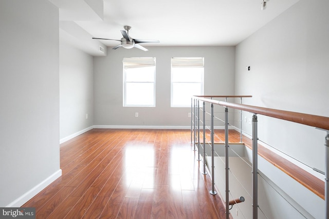 empty room with hardwood / wood-style floors and ceiling fan