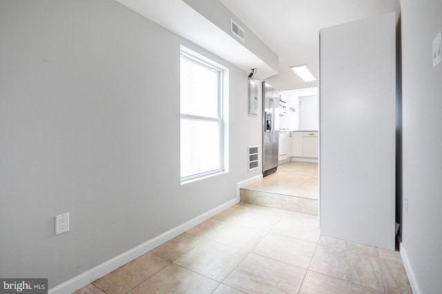 hallway featuring a wealth of natural light and light tile patterned flooring