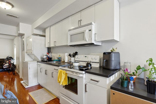 kitchen featuring white cabinetry, dark hardwood / wood-style flooring, white appliances, and sink