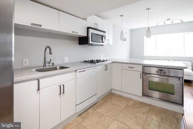 kitchen featuring white cabinets, sink, decorative light fixtures, kitchen peninsula, and stainless steel appliances