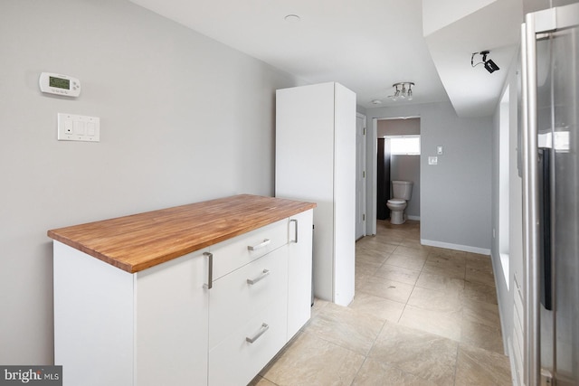 kitchen featuring white cabinets and butcher block counters