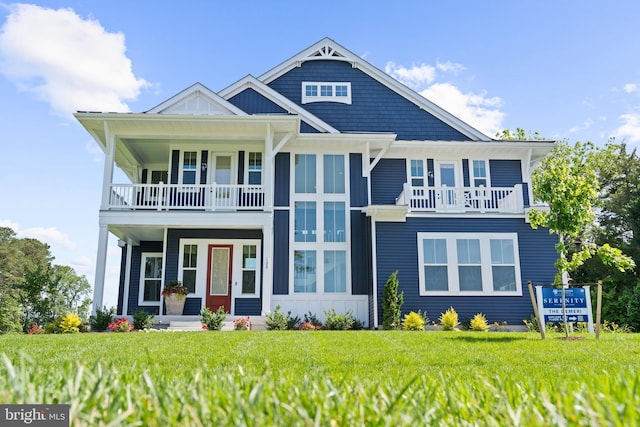 view of front facade featuring a balcony and a front lawn