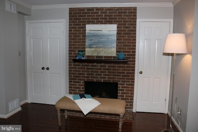 sitting room with a fireplace, crown molding, and dark wood-type flooring