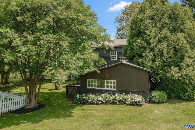 view of home's exterior featuring fence and a yard