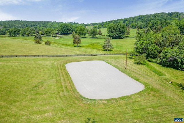 surrounding community with a yard, a rural view, and fence