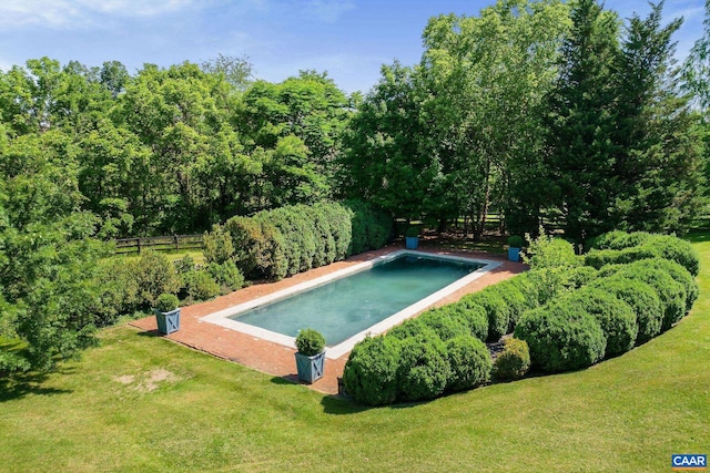 view of swimming pool featuring fence and a lawn