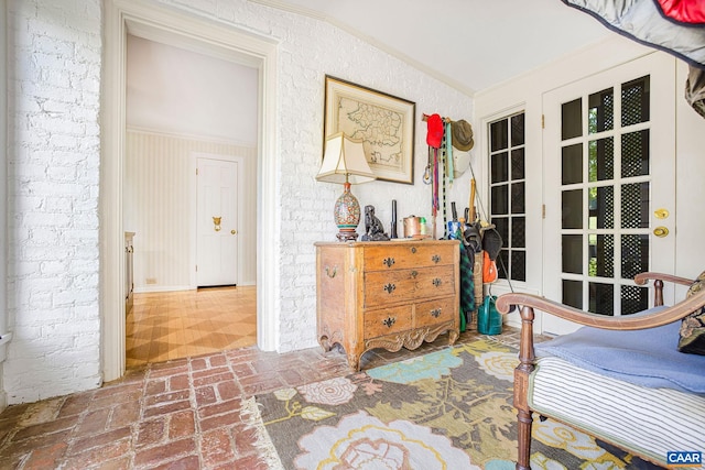 bedroom featuring brick wall, brick floor, and crown molding