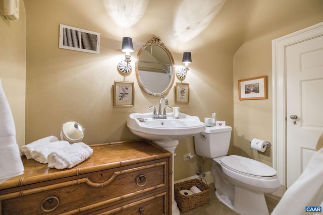 bathroom with a wall mounted air conditioner, visible vents, and toilet