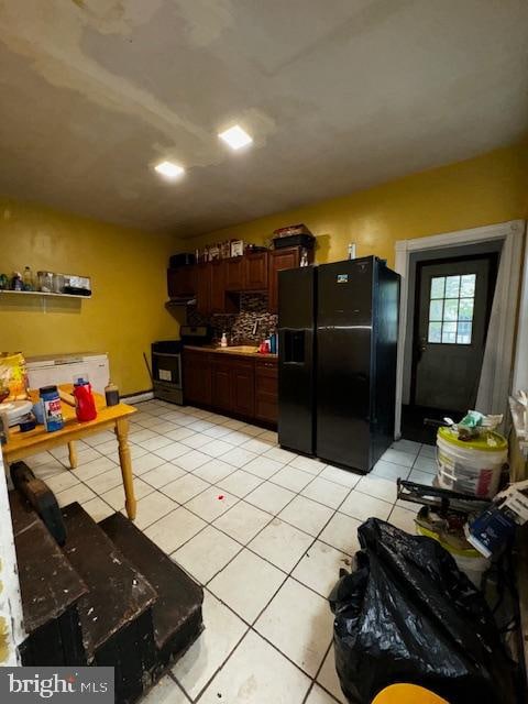 kitchen featuring black appliances, light tile patterned floors, and tasteful backsplash