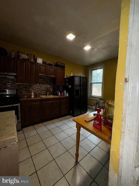 kitchen with stainless steel range with electric stovetop, sink, light tile patterned floors, black fridge with ice dispenser, and extractor fan