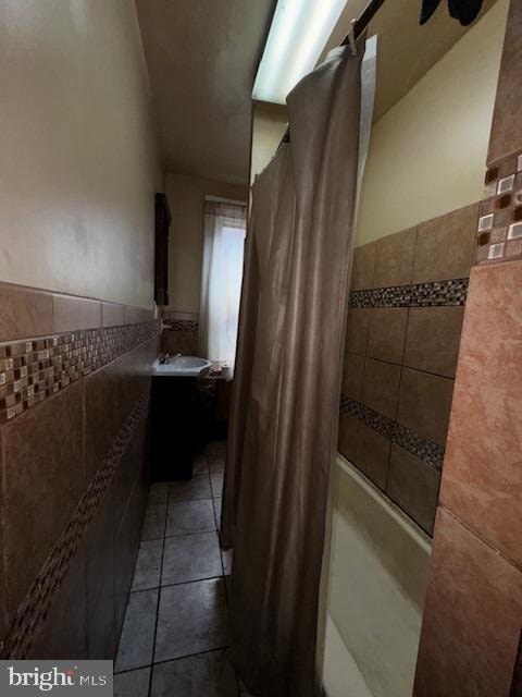 bathroom with tile patterned flooring, shower / bath combo, vanity, and tile walls