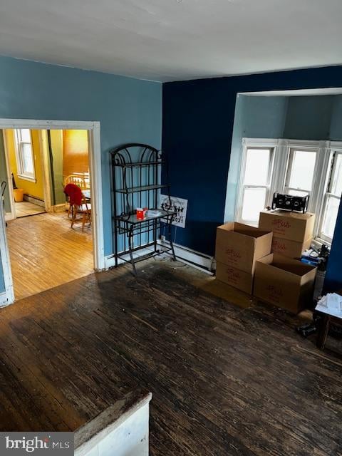 interior space featuring wood-type flooring and a baseboard heating unit