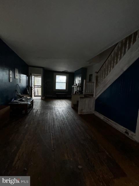 unfurnished living room with lofted ceiling and dark wood-type flooring