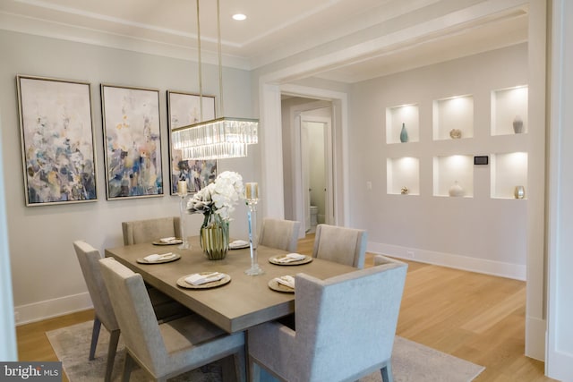 dining room with light hardwood / wood-style flooring, crown molding, and a chandelier