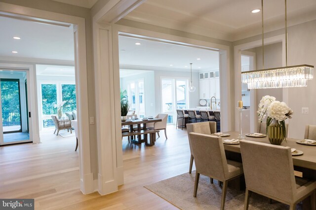 dining area with an inviting chandelier and light hardwood / wood-style floors