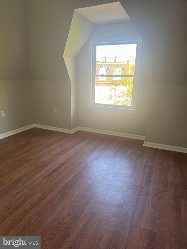 bonus room with dark hardwood / wood-style flooring and vaulted ceiling