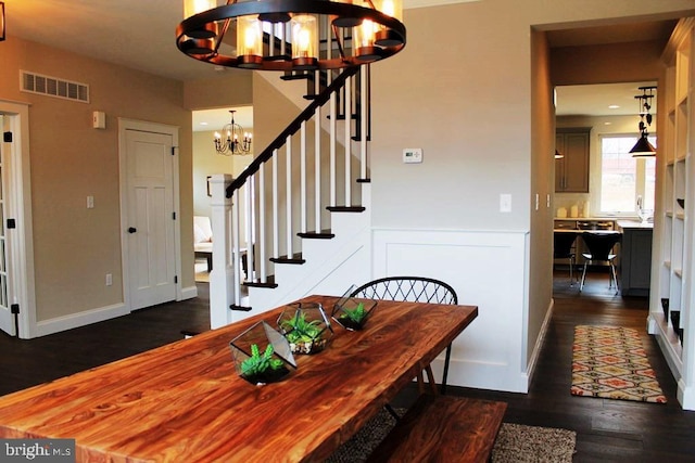 dining area featuring dark hardwood / wood-style floors and an inviting chandelier