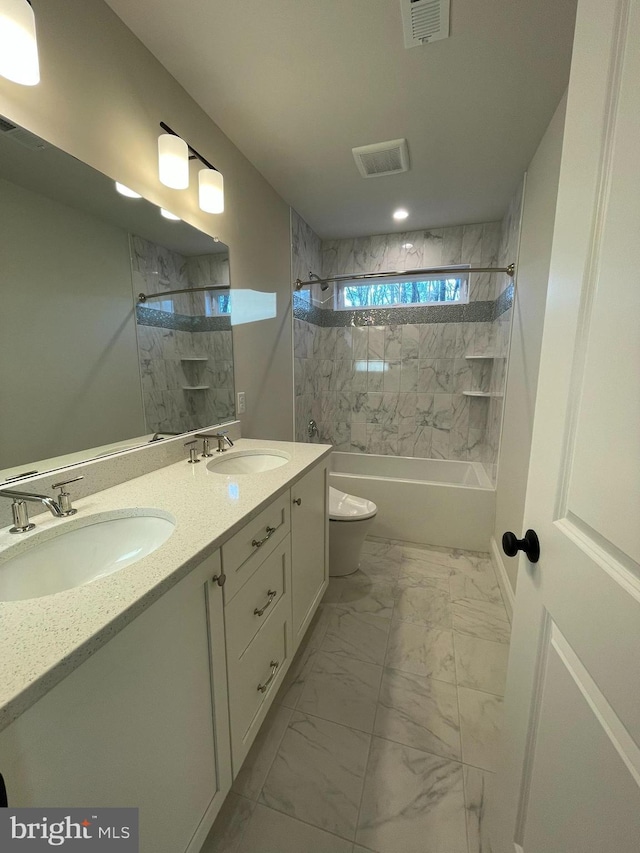 full bathroom featuring vanity, toilet, and tiled shower / bath