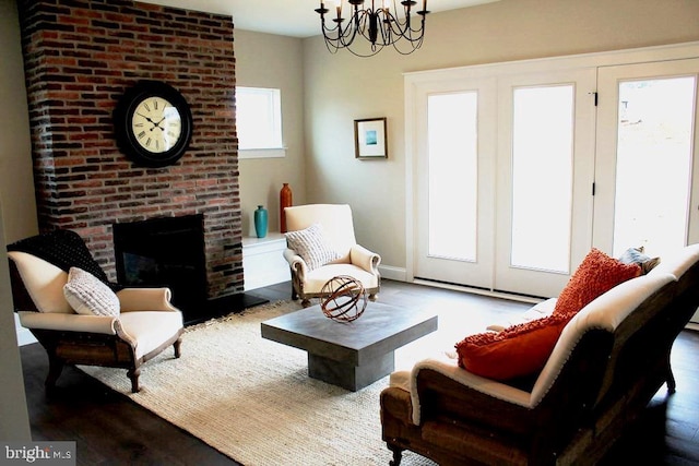 living room with a notable chandelier, a fireplace, and dark wood-type flooring