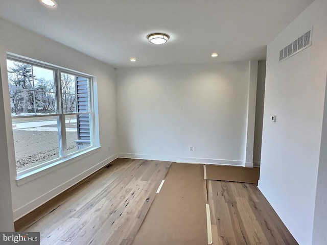 empty room with a wealth of natural light and light wood-type flooring