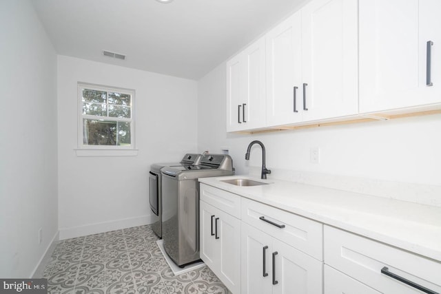 laundry room featuring sink, cabinets, and independent washer and dryer