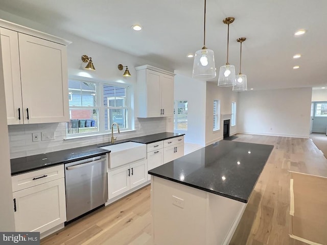 kitchen featuring dishwasher, white cabinetry, hanging light fixtures, and a healthy amount of sunlight