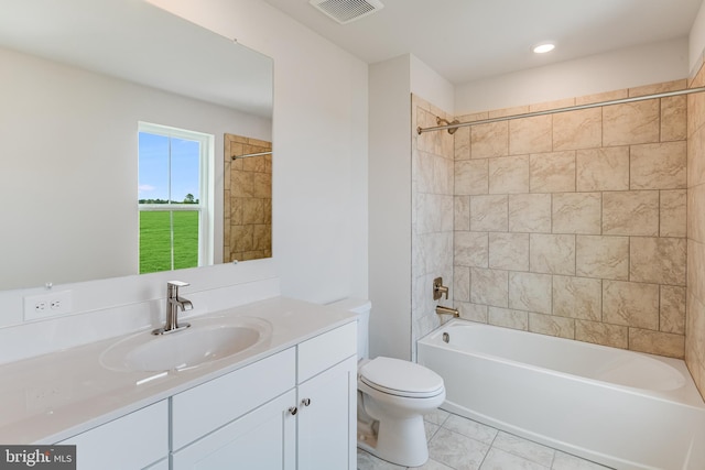 full bathroom featuring tile patterned flooring, vanity, tiled shower / bath combo, and toilet