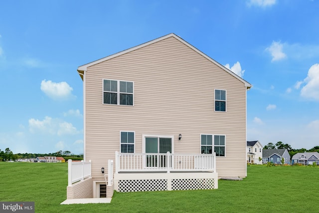 back of property with a lawn and a deck