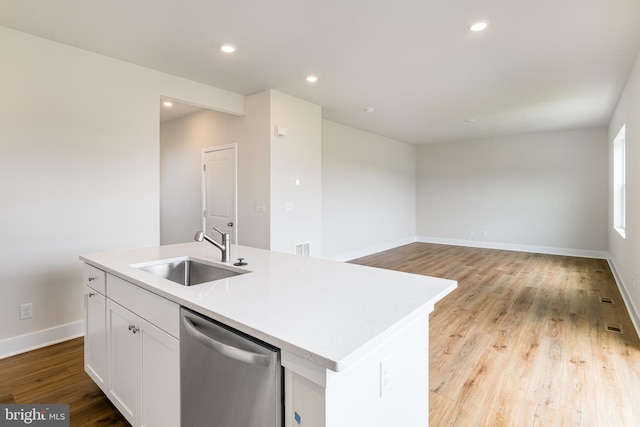 kitchen with a kitchen island with sink, dishwasher, white cabinets, and sink