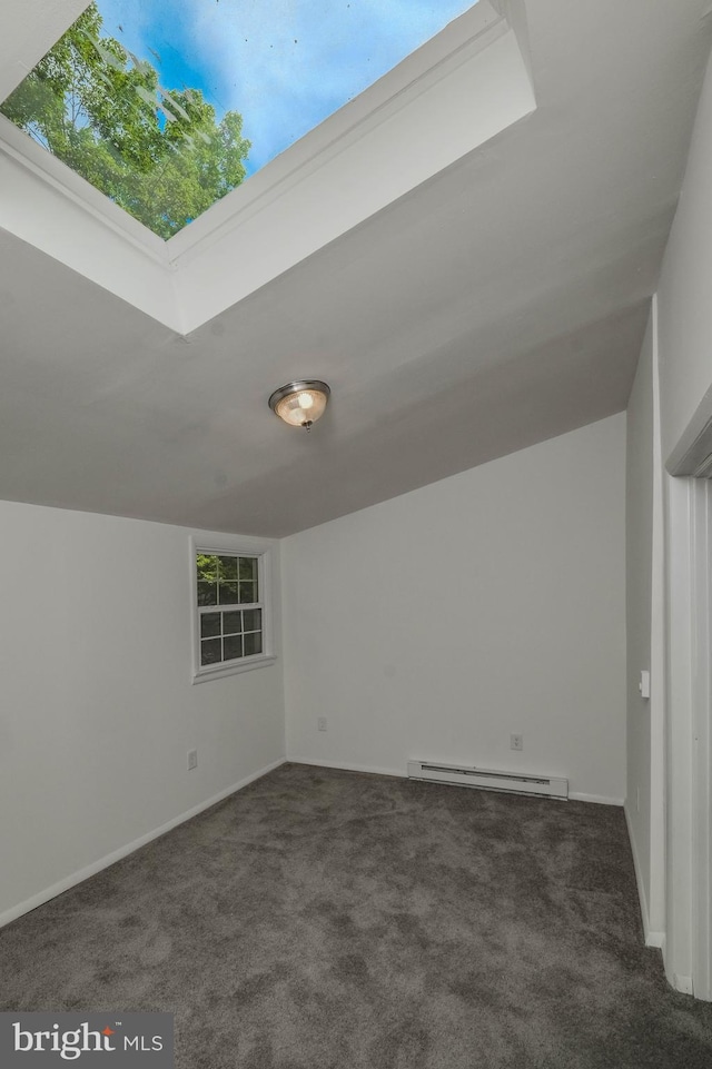 bonus room featuring vaulted ceiling, dark carpet, and a baseboard heating unit