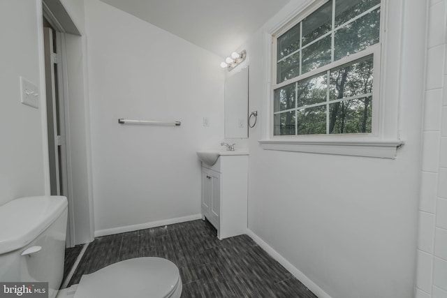 bathroom with hardwood / wood-style flooring, vanity, and toilet