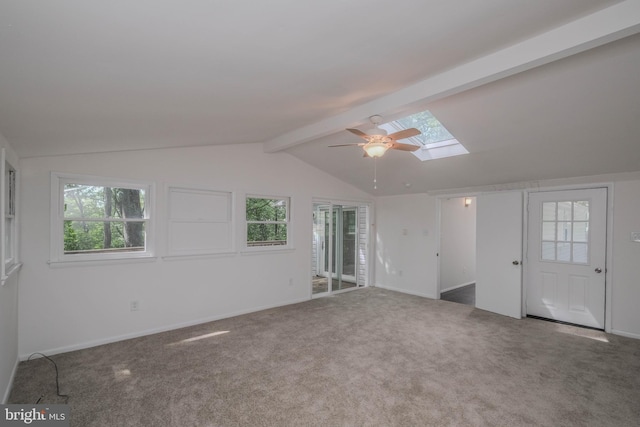 carpeted spare room with ceiling fan and lofted ceiling with skylight