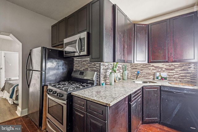 kitchen with dark hardwood / wood-style floors, sink, stainless steel appliances, and tasteful backsplash