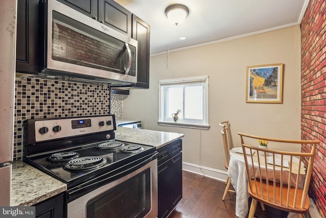 kitchen with light stone countertops, dark hardwood / wood-style flooring, crown molding, decorative backsplash, and appliances with stainless steel finishes