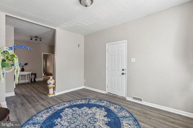 entrance foyer featuring rail lighting and dark wood-type flooring