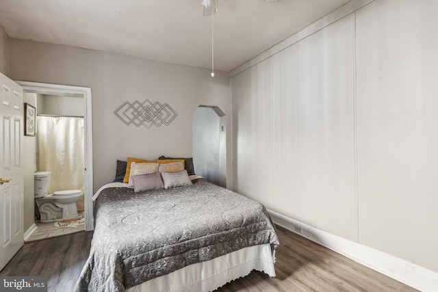 bedroom with hardwood / wood-style floors, connected bathroom, and ceiling fan