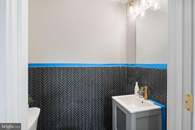 bathroom with vanity and tile walls