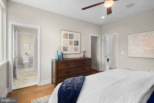 bedroom featuring hardwood / wood-style floors, connected bathroom, and ceiling fan