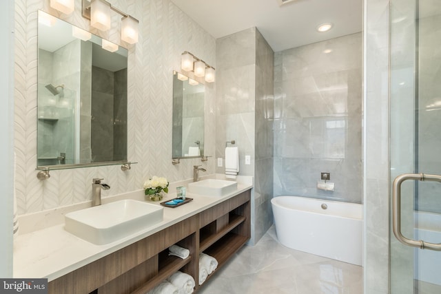 bathroom with a freestanding tub, a shower stall, tile walls, and a sink