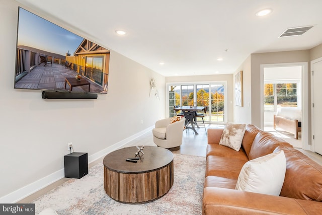 living room featuring a wealth of natural light, visible vents, and baseboards