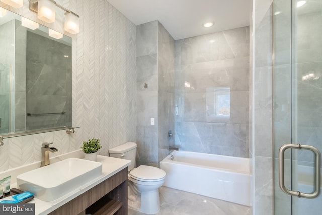 bathroom with toilet, vanity, and tile walls