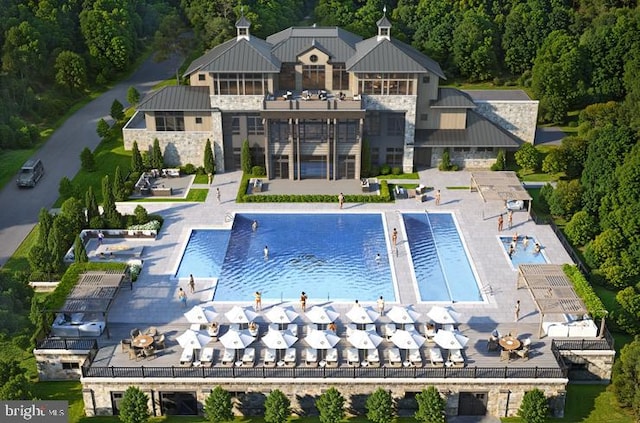 rear view of house featuring a community pool, a patio, and a balcony