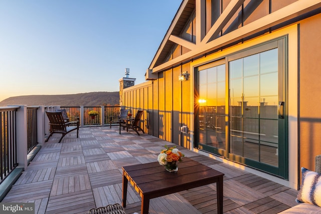 deck at dusk featuring a mountain view